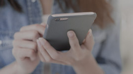 #PraCegoVer Texto: PAGAMENTOS. Imagem: moça de camisa está fazendo pagamentos pelo seu celular.